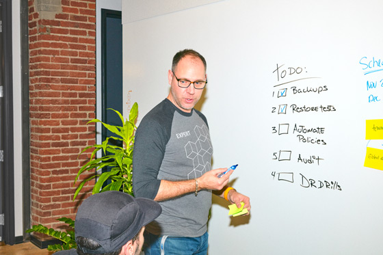 IT admin in ShareGate's office writing a to do list on a white board.